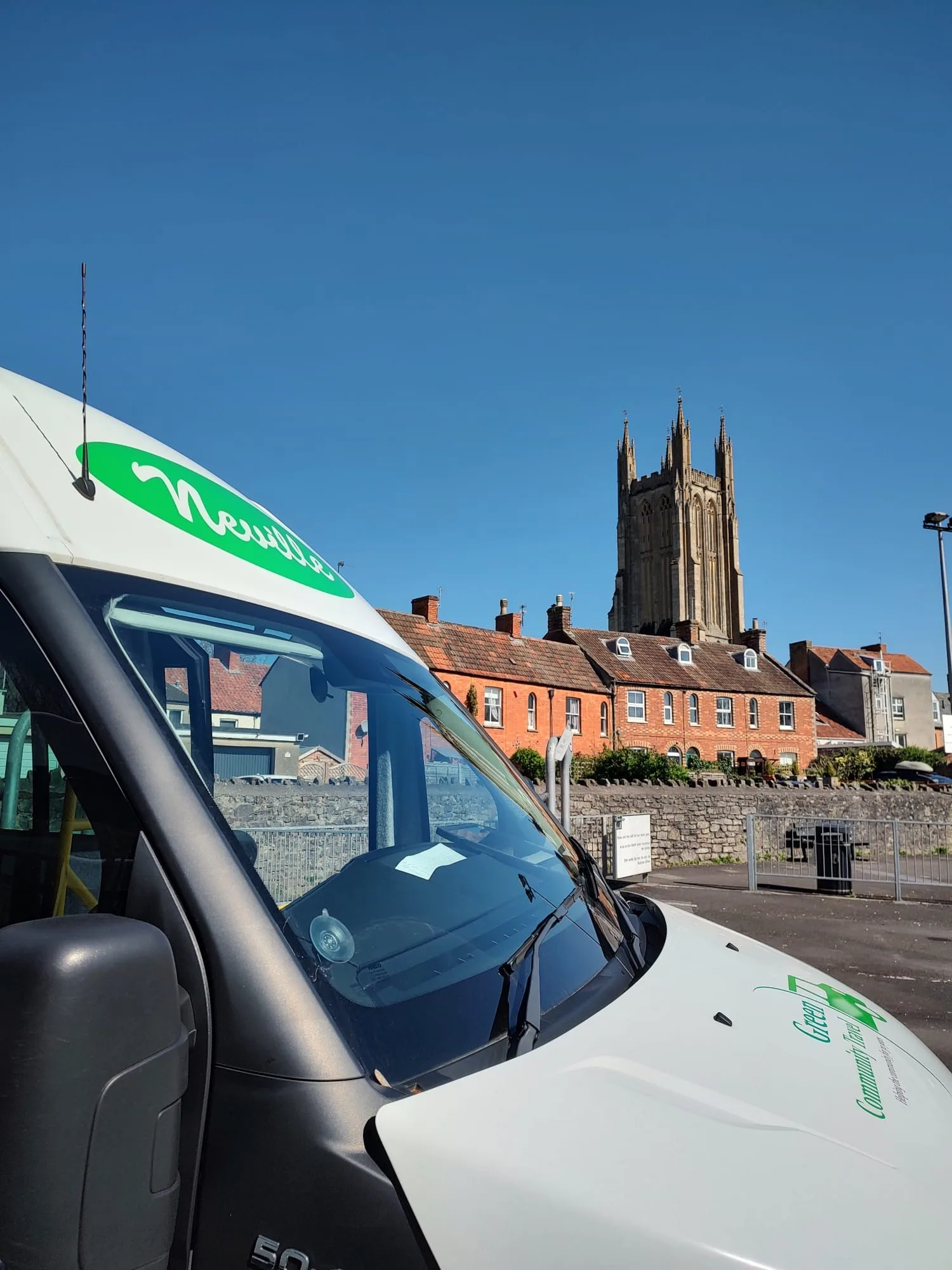 a green community travel minivan with a church in the background