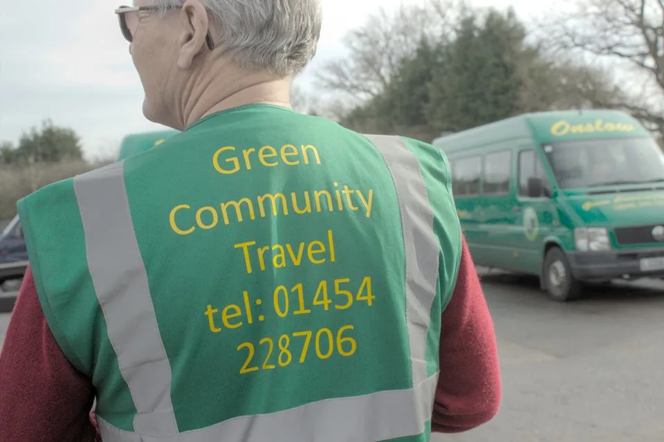 a volunteer driver with a minibus in the background